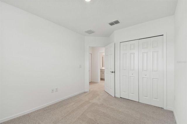 unfurnished bedroom featuring light colored carpet and a closet