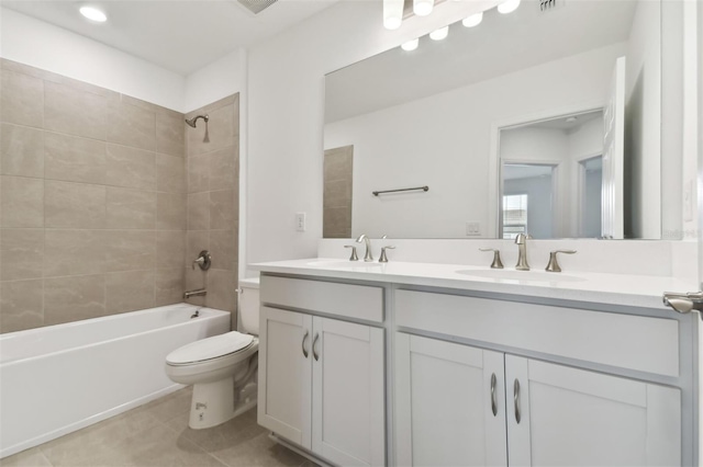 full bathroom featuring toilet, vanity, tiled shower / bath, and tile patterned flooring