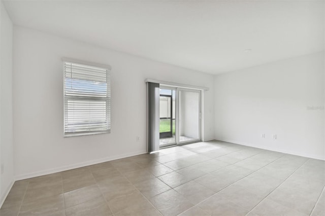 unfurnished room featuring light tile patterned floors and baseboards