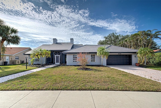 single story home featuring a garage and a front yard