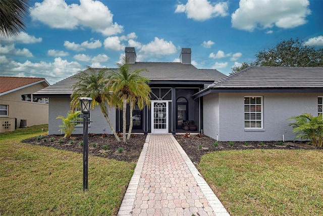 view of front of property featuring a sunroom and a front yard