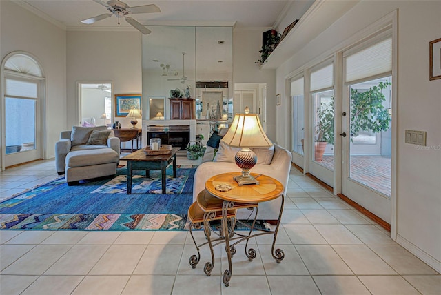 living room featuring light tile patterned floors, french doors, ceiling fan, and crown molding