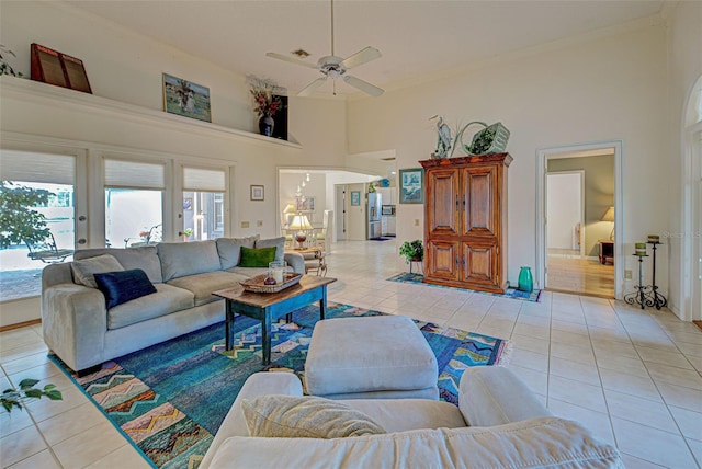 tiled living room featuring ceiling fan and a towering ceiling