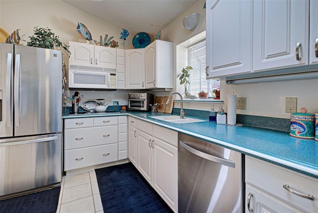 kitchen with light tile patterned floors, white cabinetry, sink, and appliances with stainless steel finishes