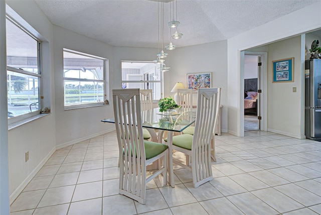 tiled dining room with a textured ceiling