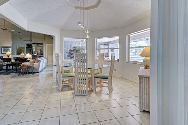 tiled dining room with ceiling fan and a textured ceiling