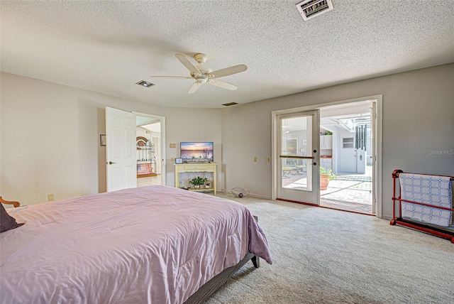 carpeted bedroom featuring access to outside, ceiling fan, and a textured ceiling