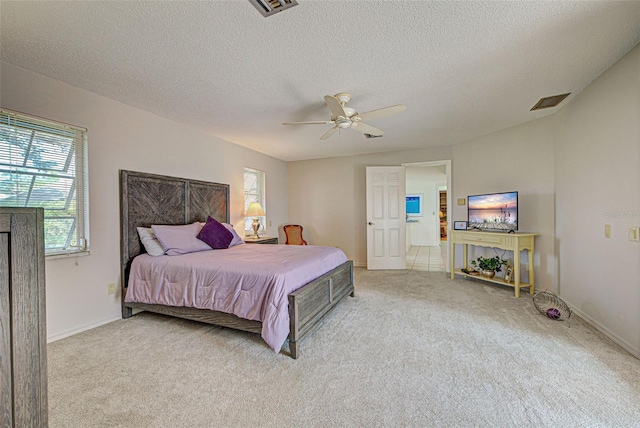 carpeted bedroom featuring a textured ceiling and ceiling fan