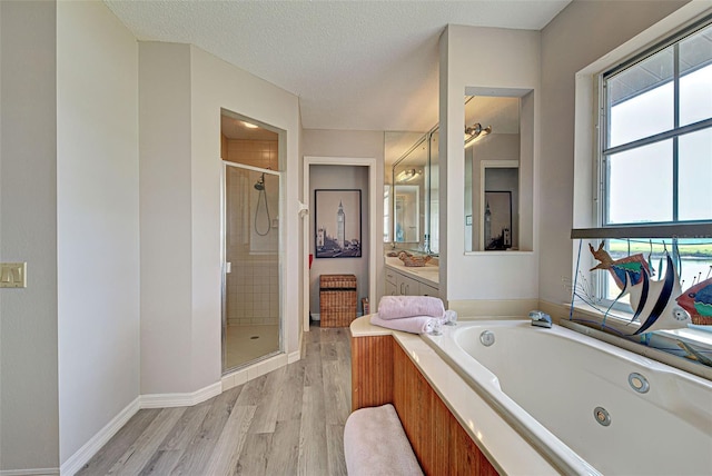 bathroom featuring hardwood / wood-style floors, vanity, a textured ceiling, and independent shower and bath