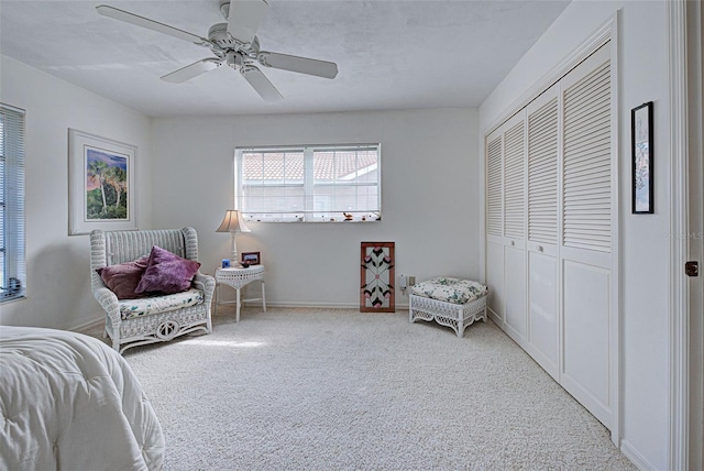 carpeted bedroom featuring ceiling fan and a closet