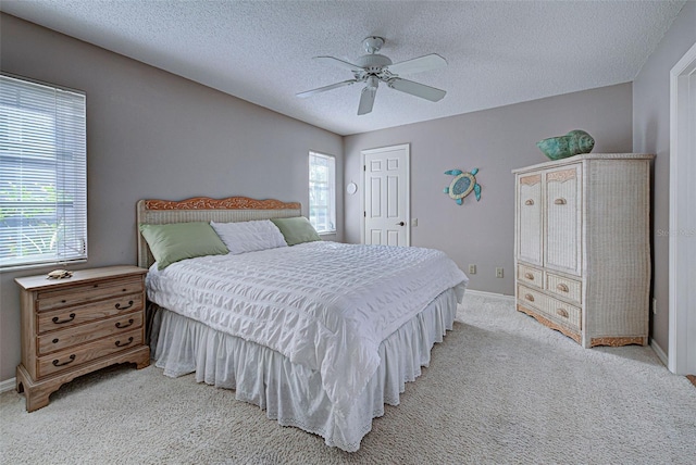 carpeted bedroom featuring a textured ceiling and ceiling fan