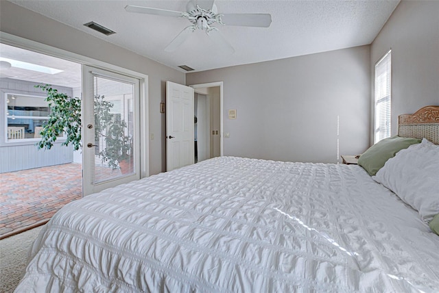 bedroom featuring access to outside, ceiling fan, and a textured ceiling