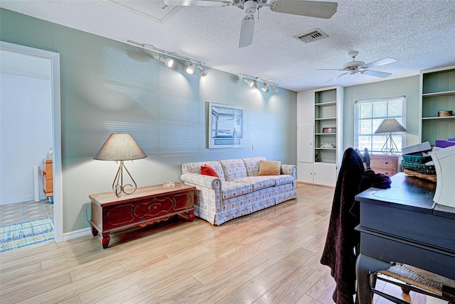 office area featuring ceiling fan, light hardwood / wood-style flooring, track lighting, and a textured ceiling