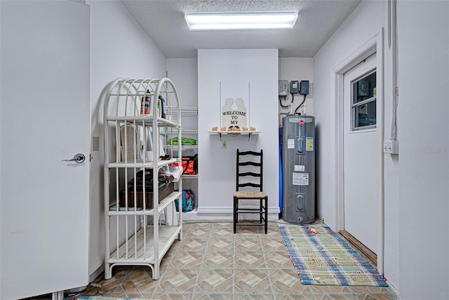 interior space with a textured ceiling and water heater