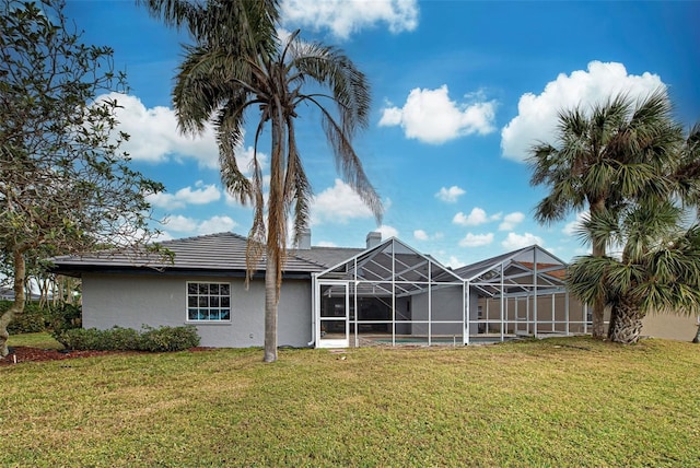 back of property with a yard and a lanai