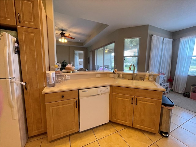 kitchen with white appliances, kitchen peninsula, light tile patterned floors, and sink