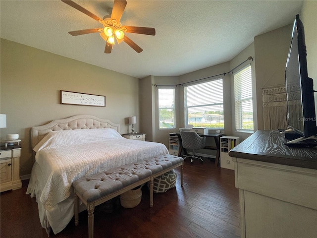 bedroom with dark wood-type flooring, a textured ceiling, and ceiling fan