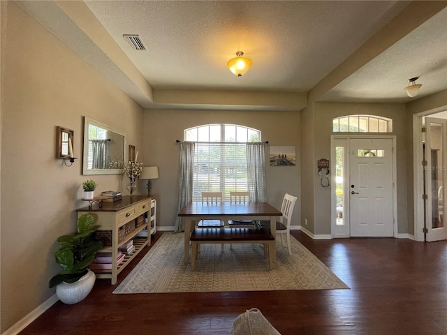 dining space featuring a textured ceiling and dark hardwood / wood-style flooring