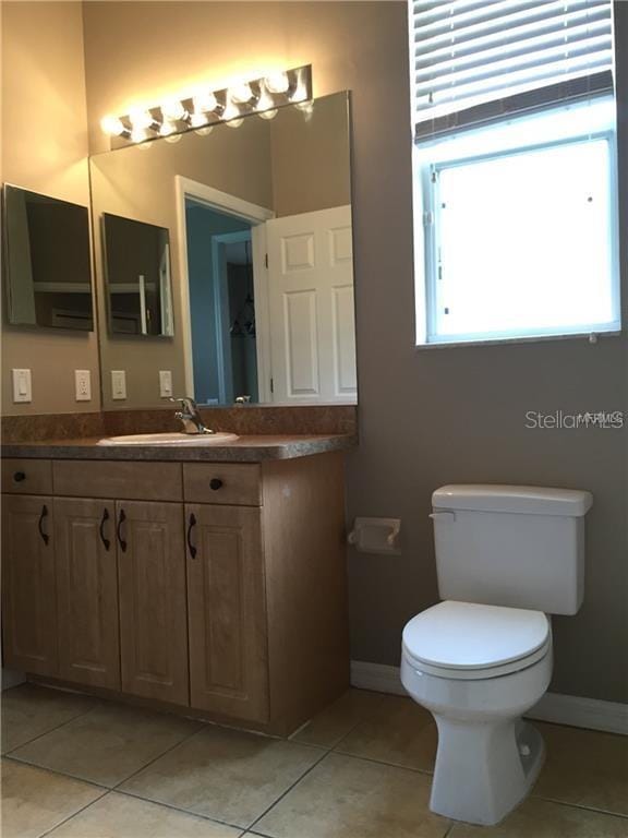 bathroom featuring toilet, vanity, and tile patterned floors