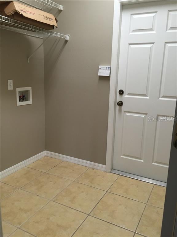 clothes washing area featuring hookup for a washing machine and light tile patterned floors