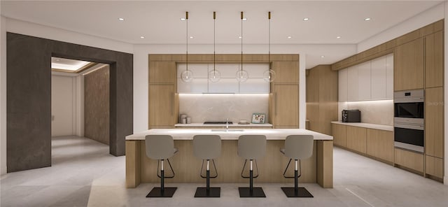 kitchen featuring pendant lighting, a kitchen bar, a kitchen island with sink, and decorative backsplash