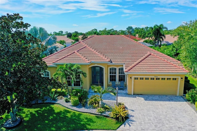 mediterranean / spanish home with a garage and a front yard