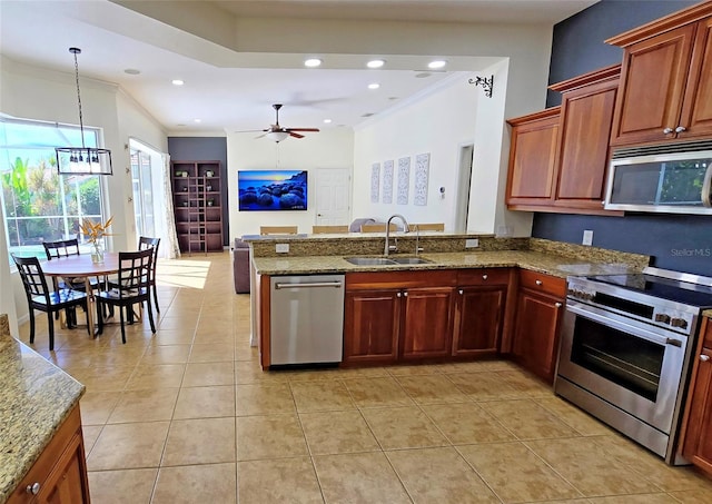 kitchen featuring appliances with stainless steel finishes, ceiling fan with notable chandelier, pendant lighting, sink, and kitchen peninsula