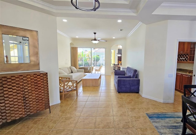 living room featuring light tile patterned flooring, ornamental molding, and ceiling fan