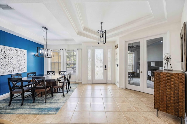 dining room featuring light tile patterned floors, an inviting chandelier, ornamental molding, french doors, and a raised ceiling