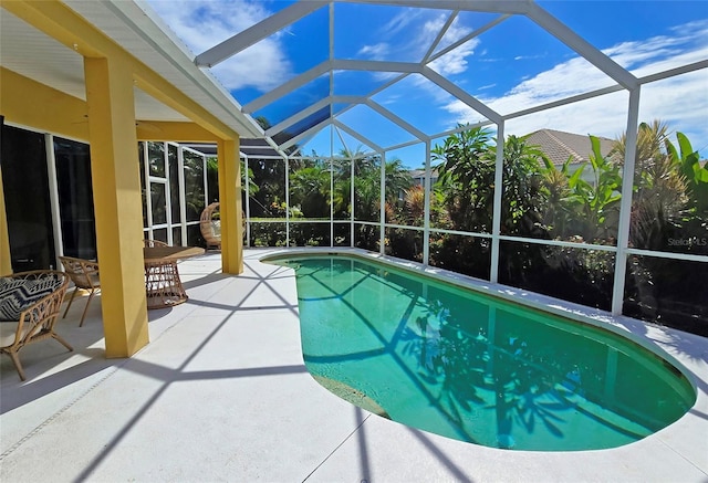 view of pool featuring a patio and glass enclosure