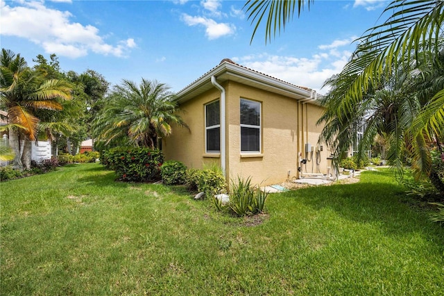 view of side of property with a lawn