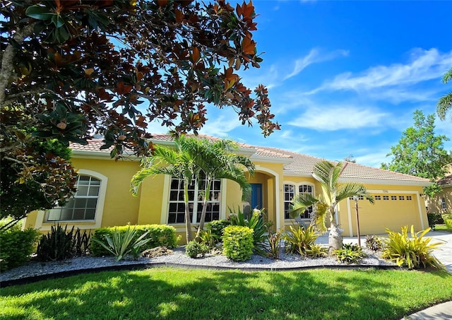 mediterranean / spanish-style home featuring a garage and a front yard