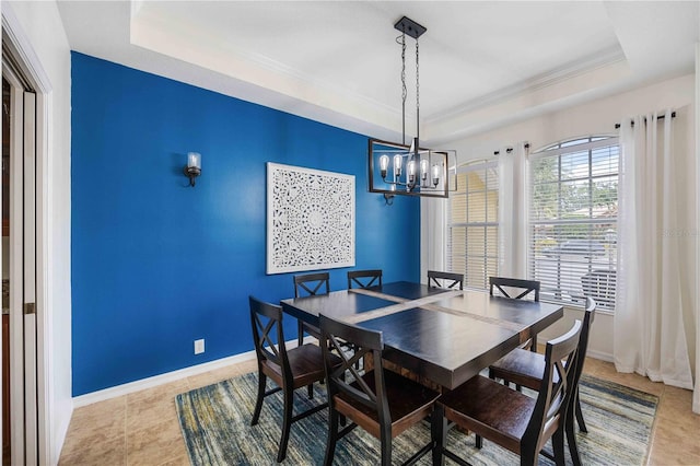 tiled dining area with a notable chandelier and a tray ceiling