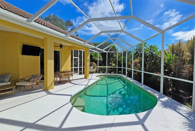 view of swimming pool with a patio, ceiling fan, and glass enclosure