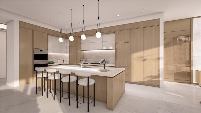 kitchen featuring pendant lighting, double oven, an island with sink, a breakfast bar area, and backsplash