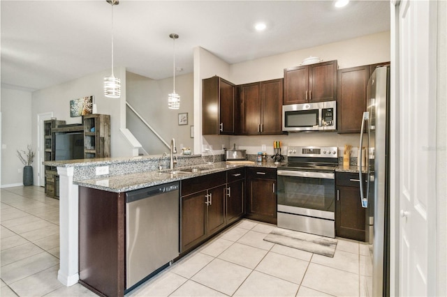 kitchen featuring kitchen peninsula, hanging light fixtures, light stone countertops, stainless steel appliances, and light tile patterned floors