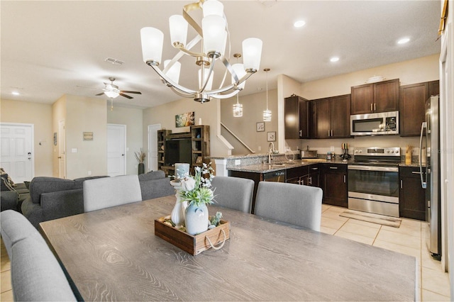 dining room featuring ceiling fan with notable chandelier, sink, and light tile patterned floors