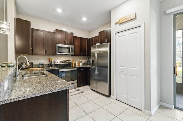 kitchen featuring sink, dark brown cabinets, light stone countertops, and appliances with stainless steel finishes