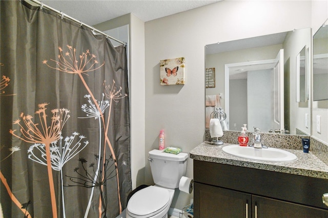 bathroom featuring toilet, walk in shower, and vanity