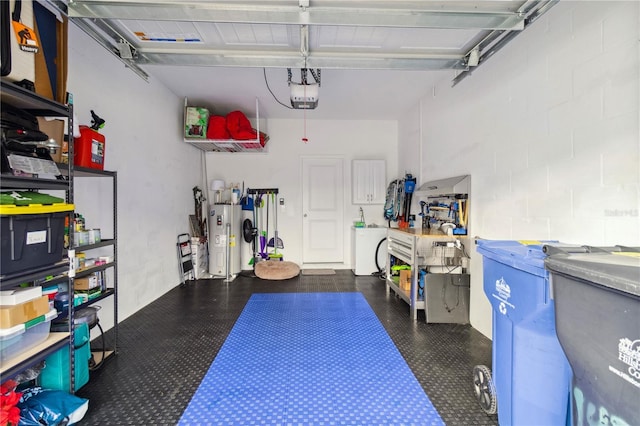 garage featuring a garage door opener, washer / dryer, and electric water heater