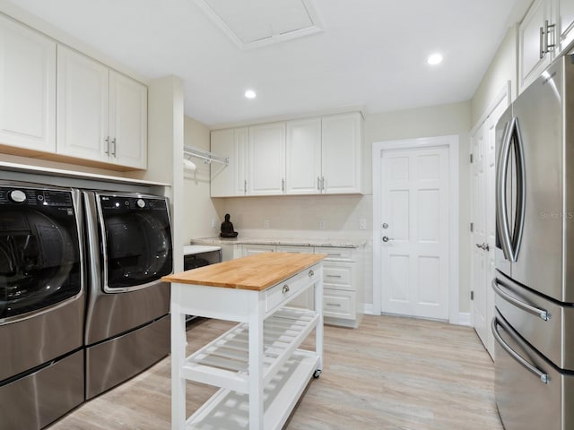 laundry room featuring washer and dryer and light hardwood / wood-style floors