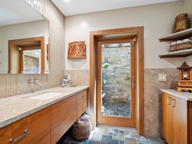 bathroom with vanity and tile walls