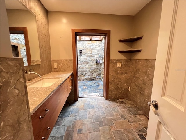 bathroom featuring vanity and tile walls