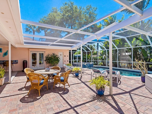 view of patio / terrace with a pool with hot tub, a lanai, and french doors