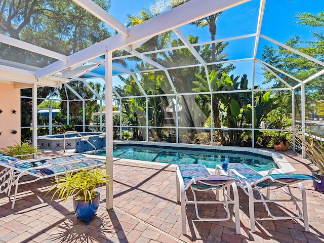 view of pool with a patio area, a lanai, and an in ground hot tub