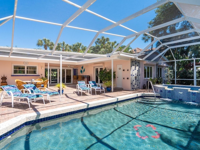 view of pool featuring a lanai, an in ground hot tub, and a patio