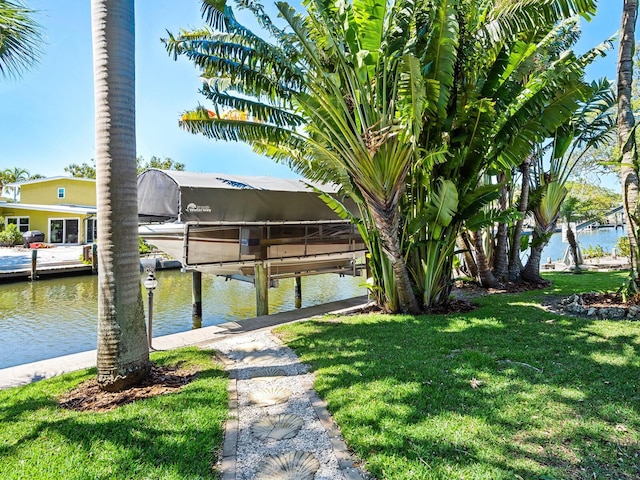 view of dock with a water view and a yard