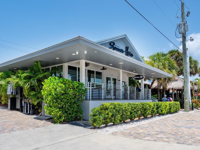 view of property exterior featuring covered porch and ceiling fan