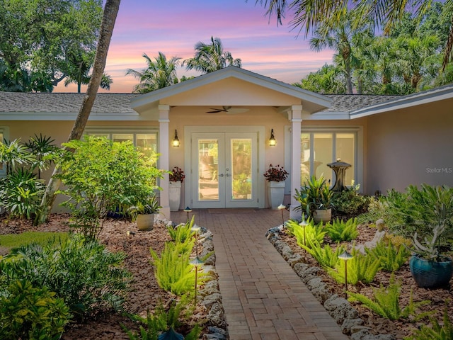 exterior entry at dusk with ceiling fan and french doors