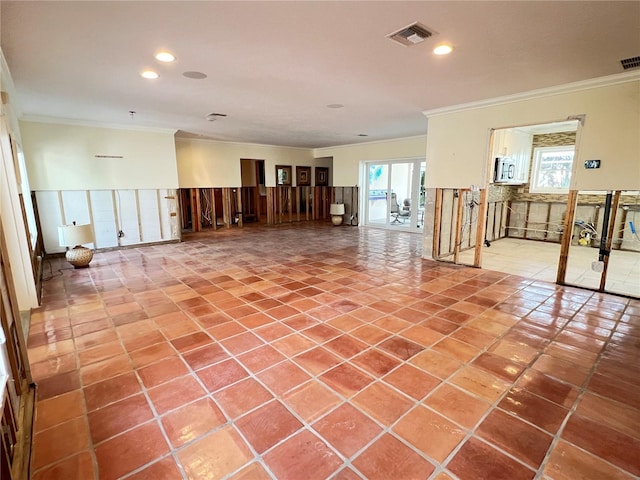 empty room with tile patterned floors, a wealth of natural light, and ornamental molding